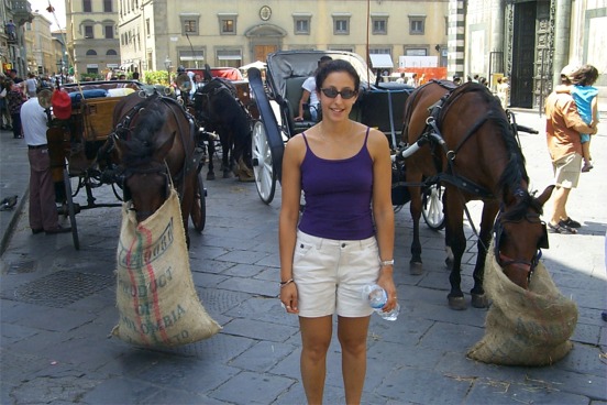 Rachel next to some horses enjoying there daily oats.  Actually I think they were bags of hay.