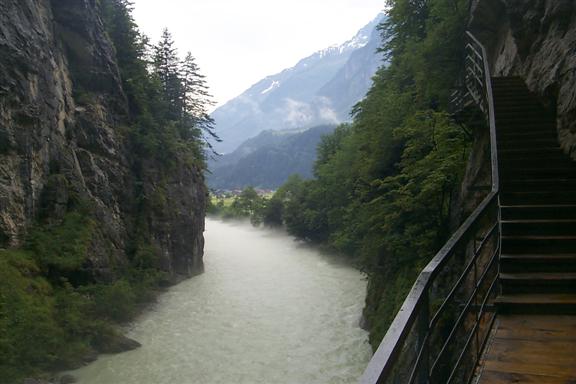The end of the gorge opens into grassy valley flanked by the Alps on all sides.