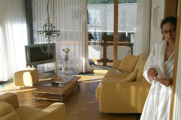 Rachel, displeased with being photographed in luxury bathrobe, and the view of the living room.  That is a wide screen TV, not that we needed it.  This place was less expensive then Lucerne for the mere fact that in Zermatt, winter is king.