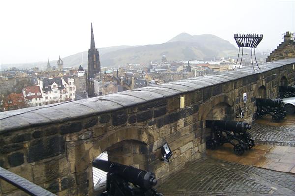 The guns of the Argyle Battery with Arthur's Seat and Salisbury Crags in the backdrop, the hill off in the distance.