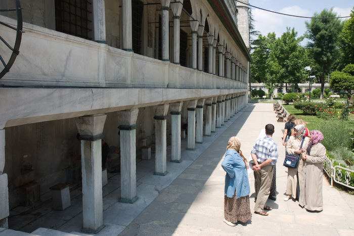 The Blue Mosque is a working mosque so there are people that come to pray.  Behind the pillars here are people washing before they go in to pray.